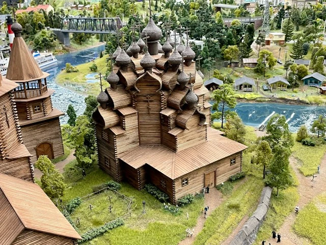 Detailed miniature church surrounded by trees and landscaped gardens