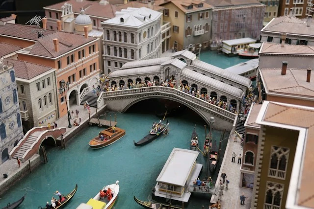 Miniature diorama of a European town with colorful buildings along a river and small canals
